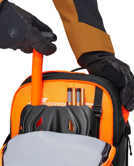 Närbild på Mammut Free 28 Removable Airbag 3.0 lavinryggsäck som visar säkerhetsfacket med spade och sond.