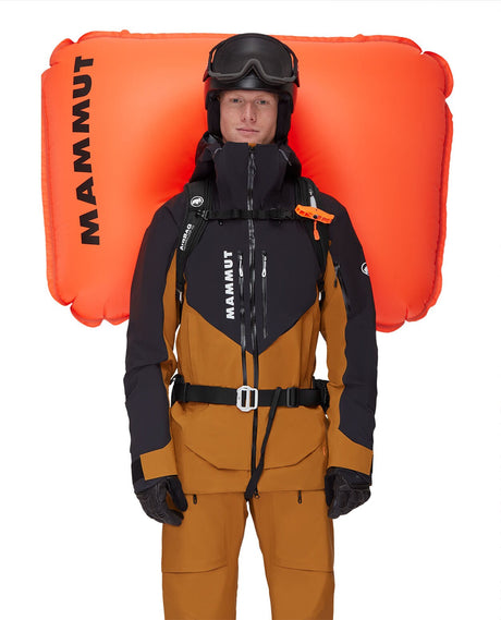En skidåkare som bär en Mammut Pro 35 Removable Airbag 3.0 lavinryggsäck i svart, med den orangea krockkudden utlöst.